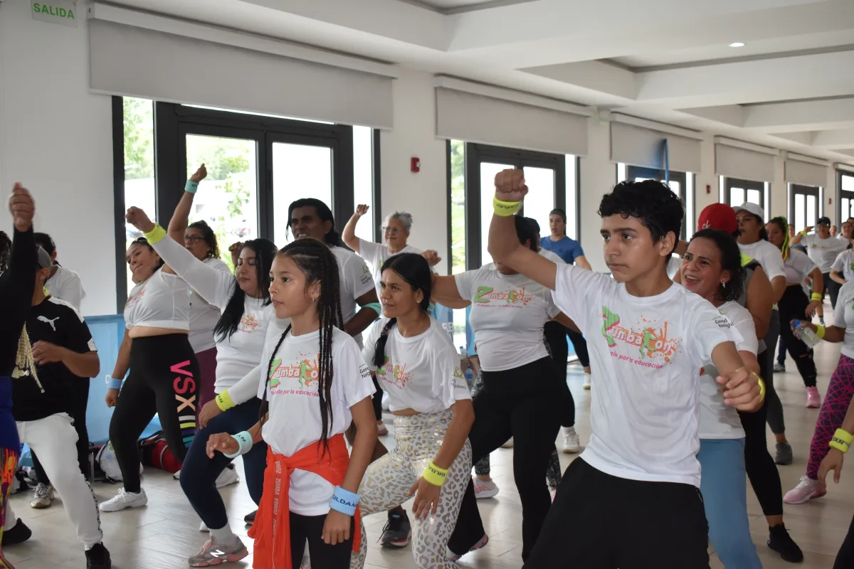 Participantes del ZumbaTón bailando con el puño en alto